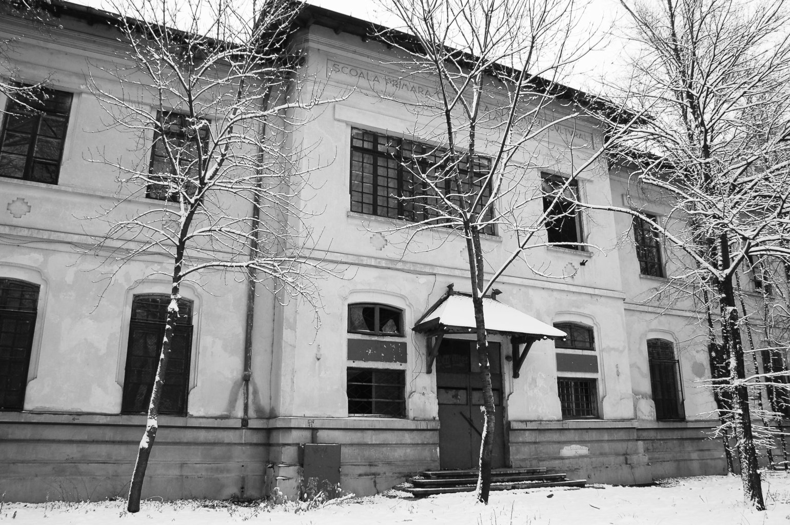 Intrarea principală în școală (decembrie 2012). Clădirea este părăsită și vandalizată de zece ani. Rezistă!